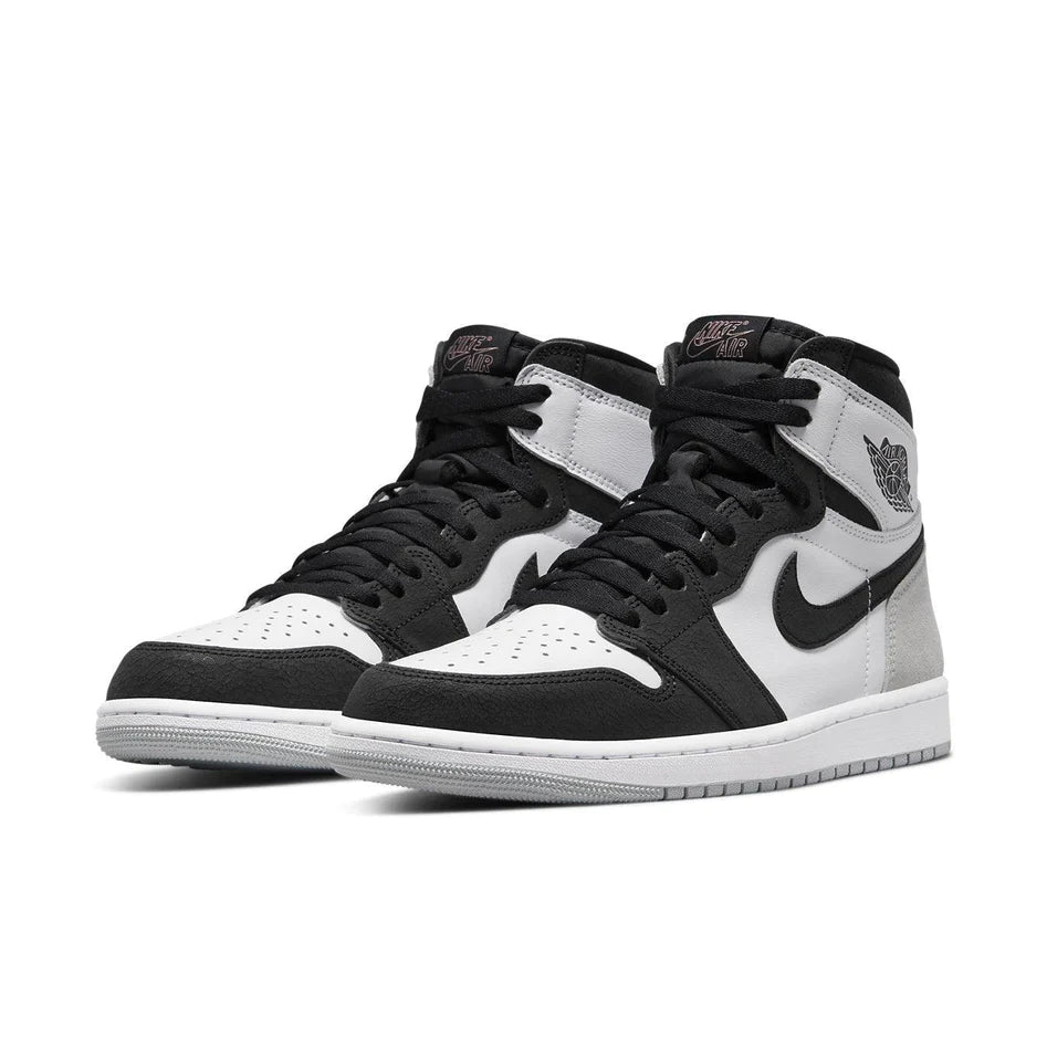 Uno stile retrò pulito entra alla ribalta, l'Air Jordan 1 High OG Stage Haze presenta una base in ciottoli bianchi con un tallone in pelle scamosciata grigio chiaro. Il grigio chiaro si trova anche sulla suola sotto l'unità Air ammortizzante. La vera star di questa colorazione è l'esclusivo effetto screpolato sui pannelli in pelle nera, che aggiunge un tocco retrò. L'ultimo tocco di colore è il rosa corallo sbiancato utilizzato sulla soletta e il marchio Nike Air sulla linguetta.